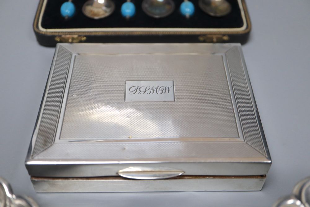A cased set of six silver bean end coffee spoons, a silver cigarette box and two white metal dishes.